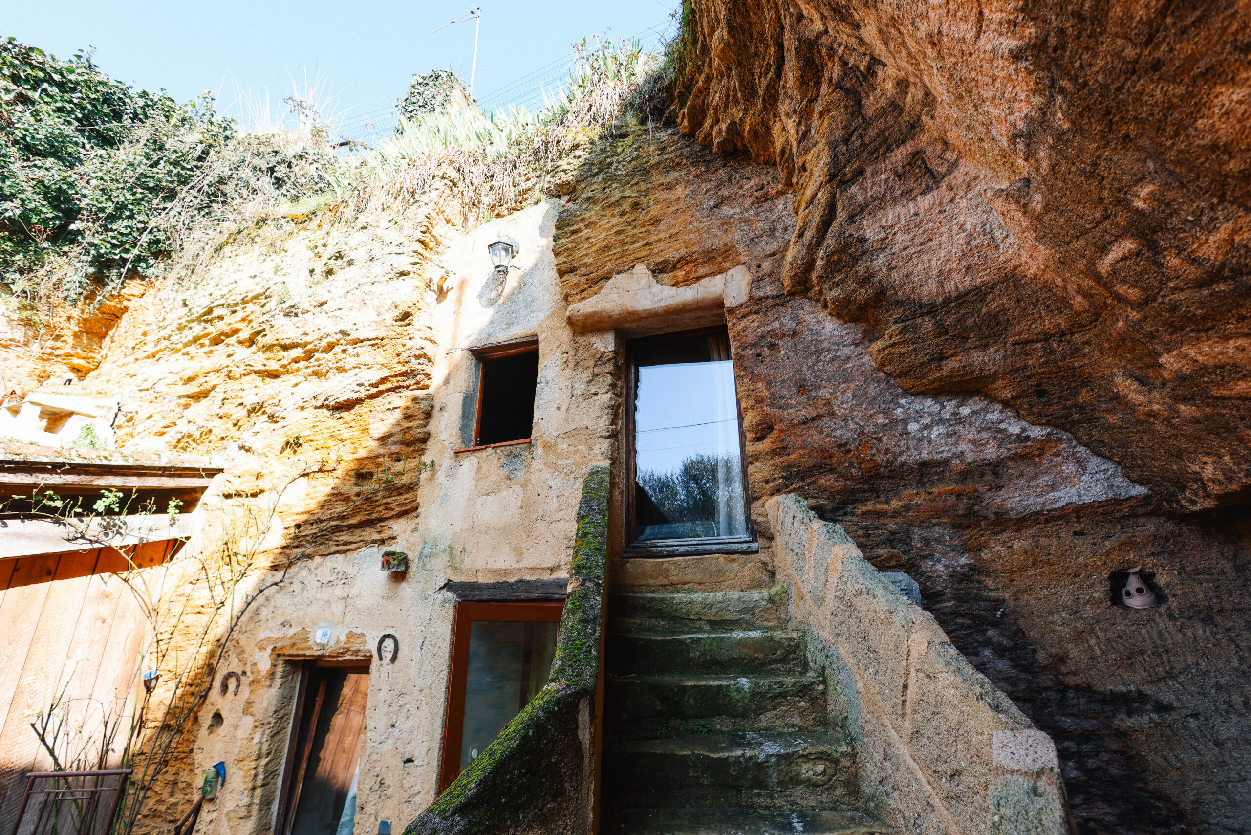 Façade troglodytique authentique avec escalier en pierre, chambres creusées à Doué-la-Fontaine aux voutes oubliees