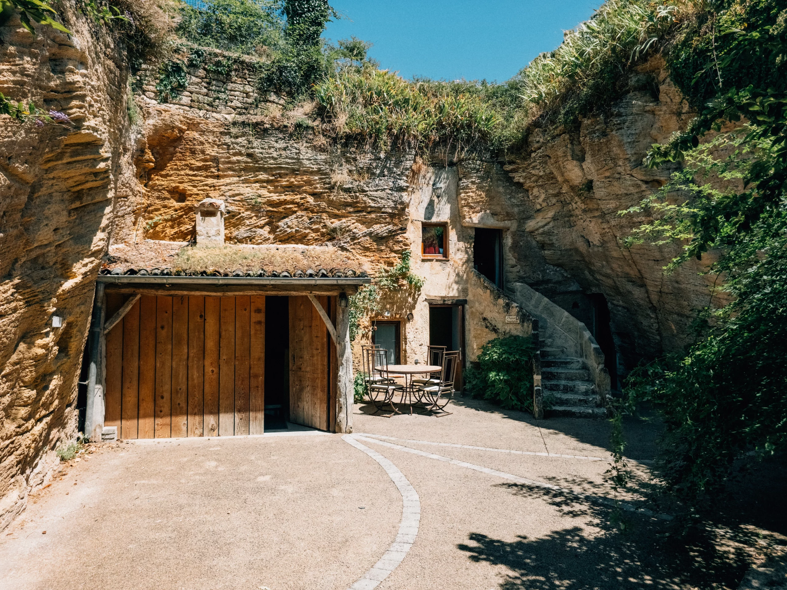 Cour extérieure végétalisée de la chambre La Rose Bleue aux Voûtes Oubliées, chambre d'hote troglodytique en Anjou
