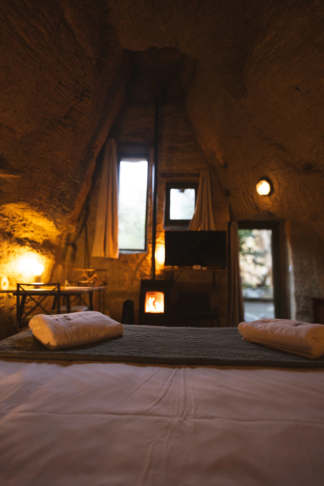 Intérieur d’une chambre troglodytique pour deux, ambiance romantique creusée dans la roche, avec poêle à Granulés